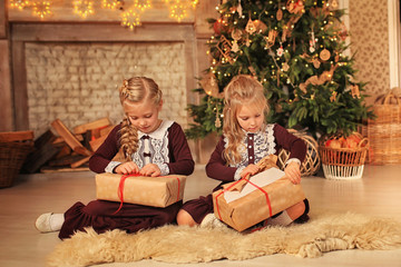 Obraz na płótnie Canvas girls with christmas gifts near the christmas tree