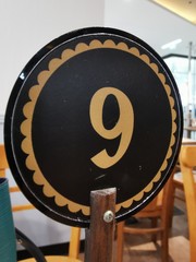 Sign showing Table number nine of a coffee and bakery or a restaurant.