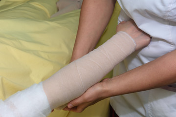 Obraz na płótnie Canvas Lymphedema management: Wrapping Lymphedema Hand and Arm using multilayer bandages to control Lymphedema. Part of complete decongestive therapy (cdt) and manual lymphatic drainage (MLD)