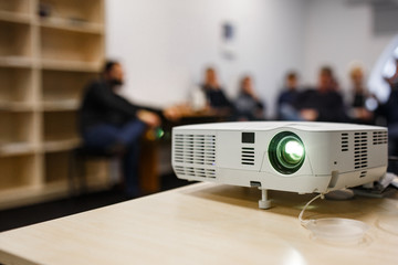 LCD video projector at business conference or lecture in a conference room or office with blurred...