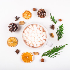 Eco friendly materials and products for Christmas decorations laid out in a circle around a cup of cocoa with marshmallows on a white background. Top view, flat lay.
