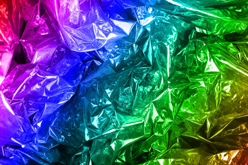 Crumpled rainbow wrapping paper with shiny effect. Close up.