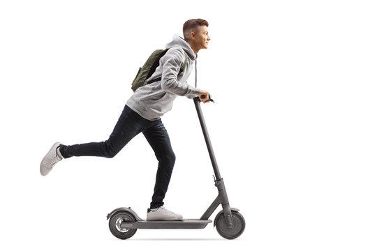 Male student with a backpack riding an electric scooter