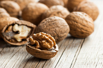 Ripe and raw whole big walnut kernel with thin shell on wooden rustic backdrop. healthy nut food for brain. Fresh walnuts background concept