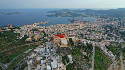 Obraz premium Aerial drone photo of iconic uphill catholic settlement of ano Syra featuring church of Saint George with beautiful colours, Syros or Siros island, Cyclades, Greece