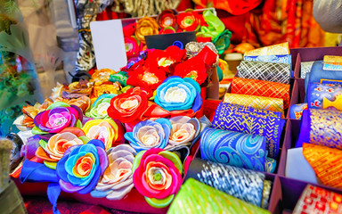 Fototapeta na wymiar Creative and bright handmade clothes for sale at stalls during Riga Christmas market in Latvia. Europe on winter. Street Xmas and holiday fair. Advent Decoration and Stalls with Crafts Items of Bazaar