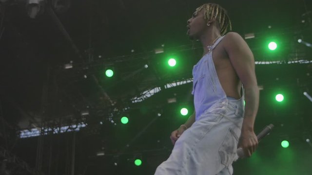 Black rapper in overalls on stage