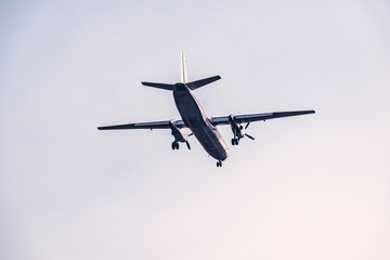 Fototapeta na wymiar Landing of the passenger retro plane in the clear sky.