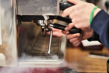 Barista making a hot drink in a coffee shop