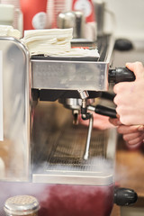 Barista making a hot drink in a coffee shop