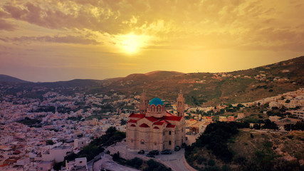 Obraz premium Aerial drone photo of iconic church of Agios Nikolaos in famous district of Vaporia in main town of Syros island - Ermoupolis at sunset with beautiful golden colours, Cyclades, Greece
