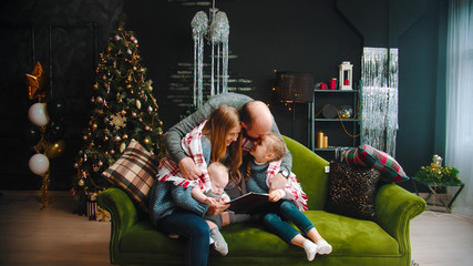 Fototapeta na wymiar Christmas concept - happy successful family sitting on the couch