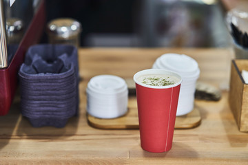 red paper cup with coffee in a coffee shop