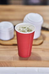 red paper cup with coffee in a coffee shop