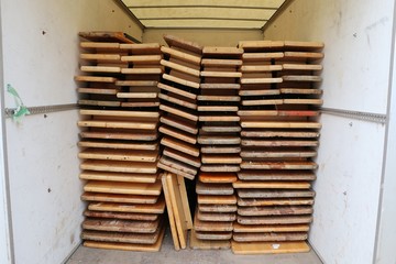 Folded wood party tables and benches stacked in the trailer