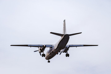 Landing of the freight military plane in the clear sky at evening time.