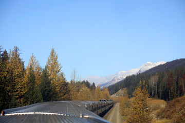 The wonderful train journey from Jasper to Vancouver in British Columbia, Canada in Autumn.  With train, trees, foliage and snow capped mountains