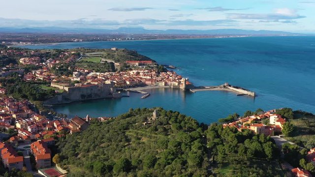 Old windmill in Collioure aerial view of the city France green trees and blue sea