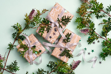 Australian native plant Grevillea frames beautiful gifts on a green background. Gifts are wrapped in luxury gold ribbon. Occasion Christmas, Birthday, Valentines Day, Anniversary or Mothers Day. 