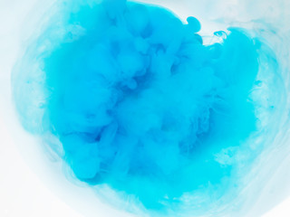 Fototapeta na wymiar a cloud of dissolving blue paint on a white background