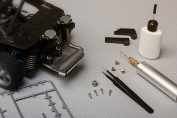 Fine point tweezers, mini drill, plastic glue, 3d printed parts, sprue, and screws used for radio...