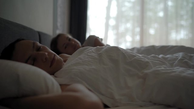 young beautiful and loving couple kissing on bed in the morning