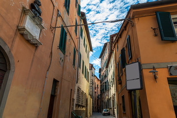 Fototapeta na wymiar Narrow old cozy street in Lucca, Italy. Lucca is a city and comune in Tuscany. It is the capital of the Province of Lucca
