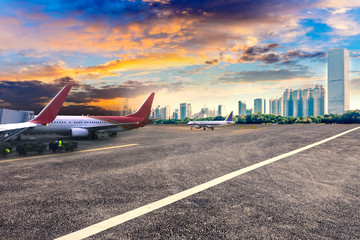 Airport asphalt runway, aircraft and modern urban architecture background