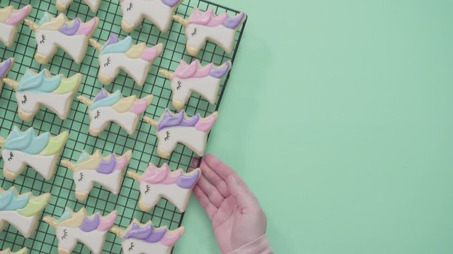 Flat lay. Unicorn sugar cookies decorated with royal icing and food glitter on a blue background.