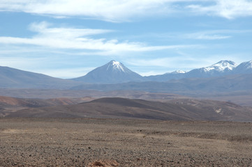 View of snow capped mountain with desert in the foreground