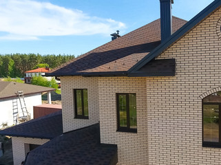 New brick house. Bituminous tile for a roof. House with a roof from a bituminous tile. a roof from a bituminous tile. Moder