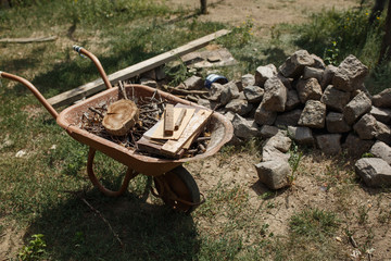stones and a cart with firewood in the rural yard