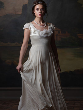 Beautiful young woman in a white long dress in the style of the 19th century.