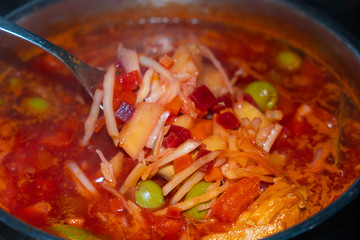 Ingredients Borsch. On a spoon are the products when the soup is cooked. Cabbage, potatoes, beets, meat and olives.