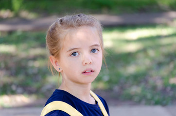 Portrait of a young blonde, blue-eyed girl outdoor
