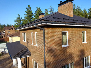 House with ceramic tile roof. cement-sand roof tiles. New brick