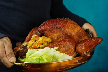 Hand holding Thanksgiving Turkey roast, close up selective focus