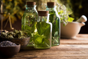 Fresh herbs and oils, wooden table background