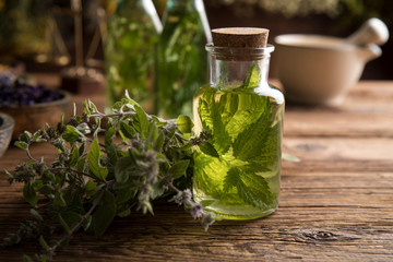 Fresh herbs and oils, wooden table background
