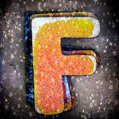 old wooden letter F in a box with Christmas stars 