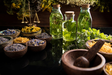 Fresh herbs and oils, wooden table background