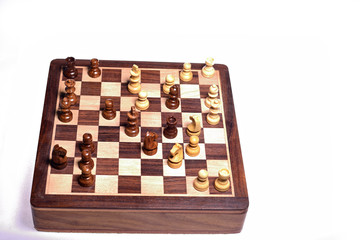 Top angle shot of chess pieces on chessboard against white background. Wooden chess pieces.