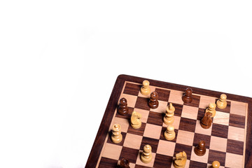 Top angle shot of chess pieces on chessboard against white background. Wooden chess pieces.