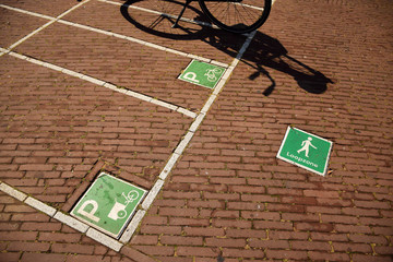 Parking space for bikes with signs telling pedestrians to go around the bikes, Amsterdam, Netherlands