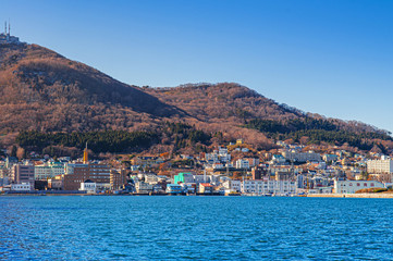 Fototapeta na wymiar Hakodate blue harbour bay and Motomachi cityscape buildings with mount Hakodate