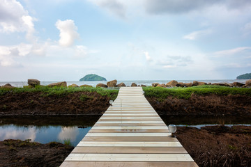 Wood bridge of walk way for travel on the sea with blue sky at Chanthaburi Province,Thailand.