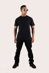 Fototapeta na wymiar Young man wearing black t shirt isolated on white background. Hipster man with tattoo wearing black t shirt.