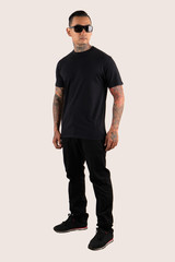 A man wearing plain t shirt isolated on white background. Hipster man with tattoo wearing black t shirt, ready for mock up design template and background.
