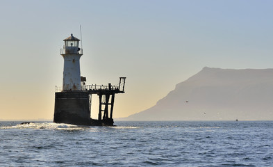 Roman Rock Lighthouse in False Bay. Standing at the entrance to Simonstown Harbour on a rock that is submerged at high tide but exposed at low water. South Africa