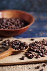 Coffee beans in wooden spoon on rustic wooden table with a blank space for a text, Coffee in cup on loft background